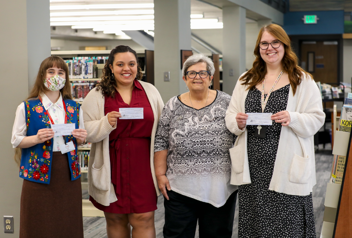 Scholarship recipients Rachael, Aliyah and Felicia receive their checks from Friends President Debra Jackson.