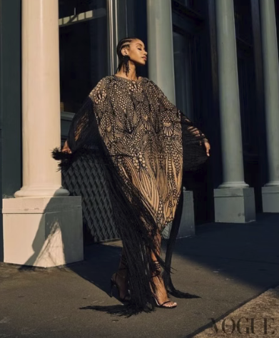 A female model wearing a brown dress with a butter fly pattern